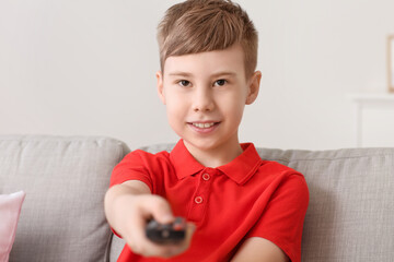 Cute boy watching TV on sofa at home