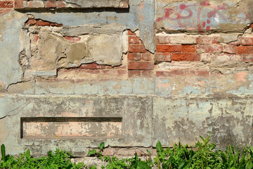 Abstract background with a texture of a natural old red brick wall with peeling plaster.