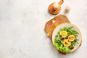 Plate with tasty arugula salad on light background