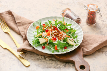 Plate with tasty arugula salad on grunge background