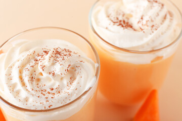 Glasses of tasty pumpkin smoothie on color background, closeup
