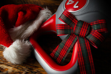 Heavy kettlebell with gift wrap bow and Santa Claus hat. Exercise equipment as a Christmas present...