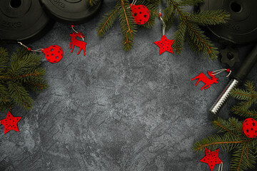 Heavy dumbbells weight plates and Christmas tree branches with decorations and ornaments. Healthy...