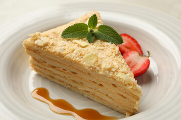 Plate with delicious Napoleon cake on white - gray background