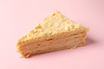 Piece of delicious Napoleon cake on pink background