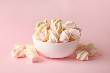 Bowl with marshmallow on pink background, space for text