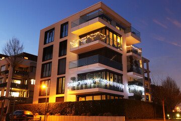 Symbolbild modernes Wohnen: Nachtaufnahme von einem modernen Apartmentgebäude im urbanen Stil