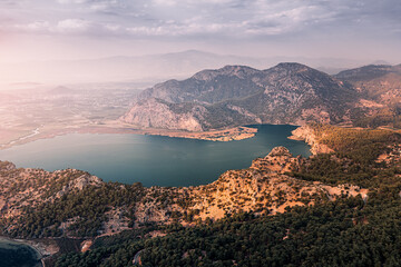Scenic aerial paniramic view from mountain Bozburun to Iztuzu beach and the Dalyan river Delta as well as lake Sulungur at sunset time. Majestic autumn landscape. Explore natural wonders of Turkey