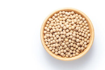Soybean seeds in a wooden bowl isolated on white background. Top view.