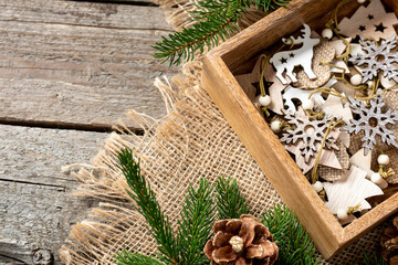 Wooden Christmas decorations in a wooden box. Ecological Christmas decorations in a box under the fir branches	