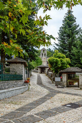 Traditional architecture with  narrow  stone road and  Agios Athanasios stone built  church during  fall season in the stone  village Monodendri central Zagori Greece