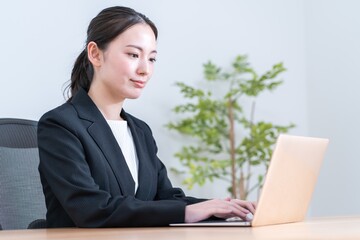 パソコンを操作するアジア人女性