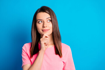 Photo portrait of curious female brunette looking at blank space thinking about idea isolated on vivid blue color background