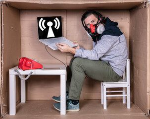 employee works from his own cardboard office to isolate himself from others