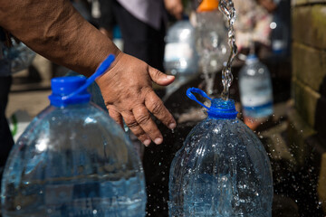 Collecting natural spring water with day zero water crisis with plastic water bottle at Newlands natural spring Cape Town South Africa with water shortage disaster. 