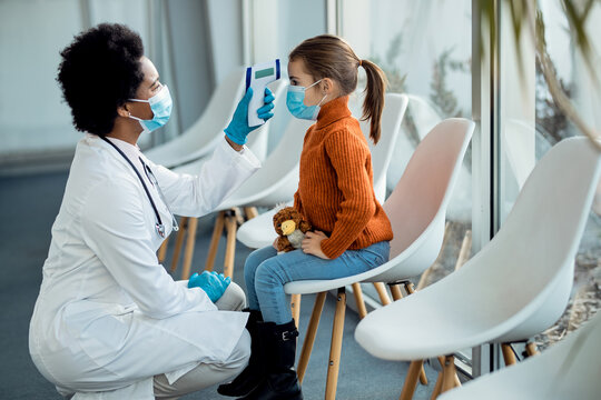 Pediatrician taking girl’s temperature during COVID 19 pandemic