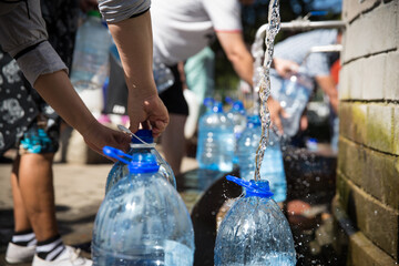 Collecting natural spring water with day zero water crisis with plastic water bottle at Newlands...