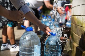 Collecting natural spring water with day zero water crisis with plastic water bottle at Newlands...
