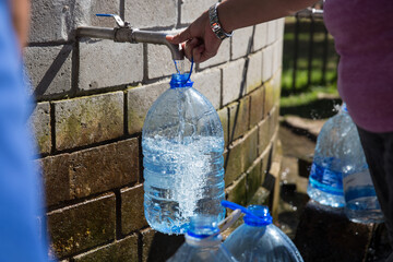 Collecting natural spring water with day zero water crisis with plastic water bottle at Newlands...