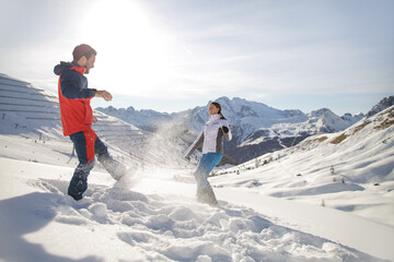 Young couple playing with snow on mountain