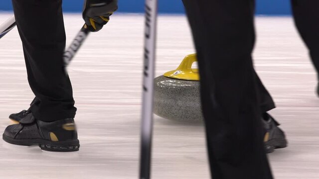 Curling. Winter Olympic sport. Curling stone. Winter sport in which players slide stones on a sheet of ice to special target.