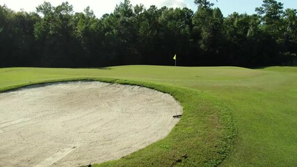 Golf course, oak trees, greens and golf carts with people playing on 18 hole course in Georgetown, South Carolina