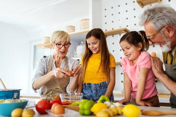 Happy senior couple having breakfast with their grandchildren at home