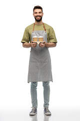 people, profession and job concept - happy smiling barman in apron holding takeaway coffee over white background