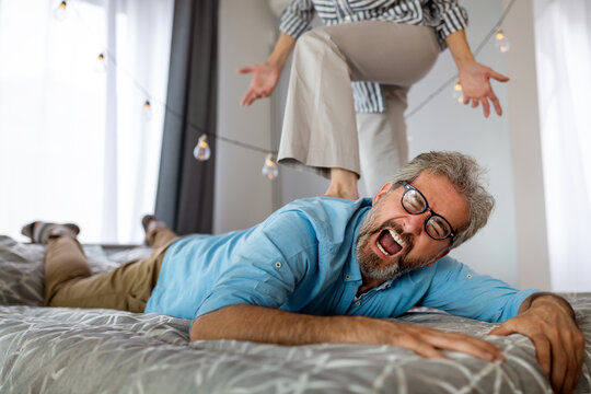 Senior couple having a forplay for bdsm, female dominance sex.