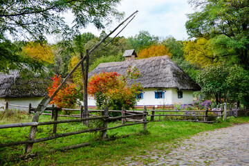 Fototapeta na wymiar Beautiful view on ancient huts on the edge of a forest. Ukrainian heritage folk architecture village.