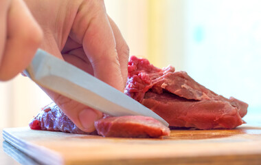 a woman cuts meat with a knife on a cutting Board