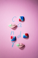 Overhead view of candies on pink background