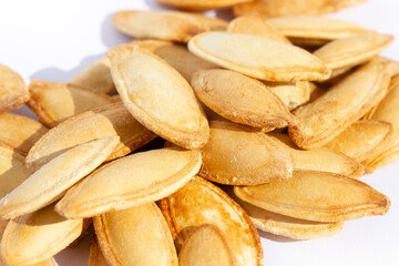 Pile of toasted Pumpkin seeds on white background