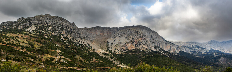 Mount Parnassus with green hills and cloudy moody skies, scenic background.