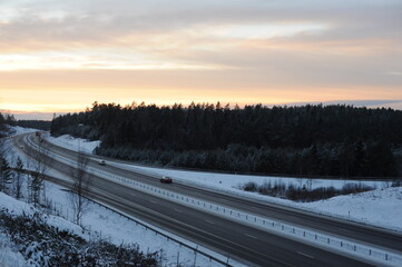 Winter driving on a snowy highway road during dusk and sunset in Sweden, Europe, Scandinavia