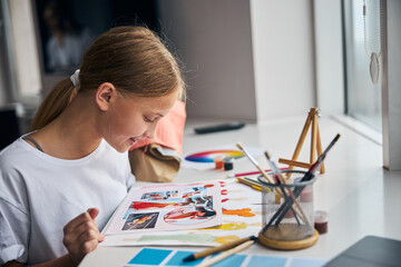 Pleased young stylist learning new fashion trends