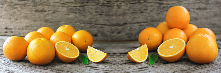fresh orange fruits with leaves on wooden table.