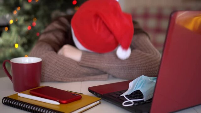 female studentin santa hat makes conference video call on laptop computer talks with web tutor, online teacher in remote webcam chat on screen. Distance education class concept.