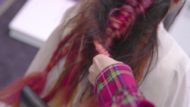 hands close up braiding pink hair female customer extravagant hairstyle slow motion