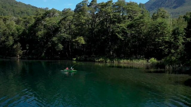Dolly in of two skilled dry fly fishers catching trouts near the shore in Lake Steffen, Patagonia Argentina. Slow motion.