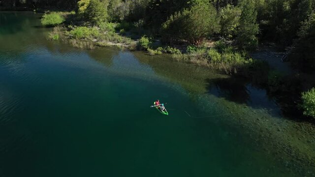 Aerial lowering of a couple of skilled dry fly fishers catching trouts near the shore in Lake Steffen, Patagonia Argentina.