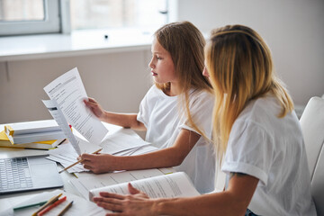 Adolescent girl keeping two papers in her hands