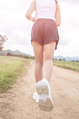 Happy Funny little asian girl fitness woman running at morning tropical forest trail. Athletic young child running in the nature. Healthy lifestyle.