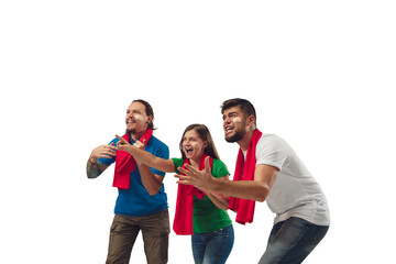 Fototapeta premium Hopeful. Three soccer fans woman and men cheering for favourite sport team with bright emotions isolated on white studio background. Looking excited, supporting. Concept of sport, fun, support.