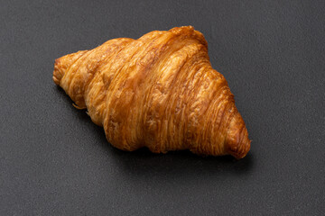 Classic French croissant on a black table. Bakery products.