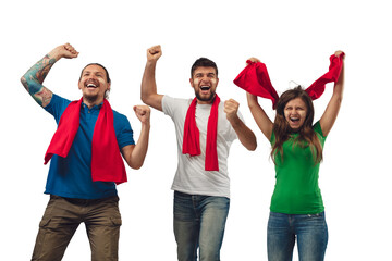Fototapeta premium Excellent goal. Three soccer fans woman and men cheering for favourite sport team with bright emotions isolated on white studio background. Looking excited, supporting. Concept of sport, fun, support.