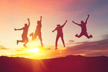 Silhouette friends jump and birds fly on sunset sky at top of mountain abstract background.