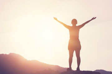 Obraz premium Copy space of woman rise hand up on top of mountain and sunset sky abstract background.