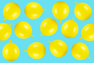 Pattern made of yellow balloons on blue background 