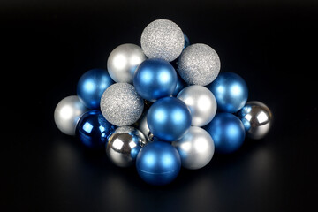 Composition from a blue and silver shiny and matte christmas balls close up view on black background